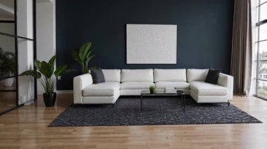 Bu şık ve modern oturma odasında canlı yeşilliklerle birlikte güzel beyaz bir kanepe sergileniyor.