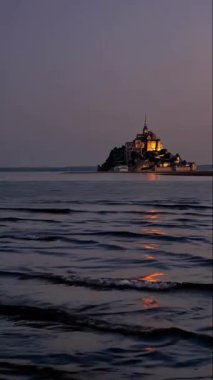 Alacakaranlık sırasında sakin suları harika yansıtan sakin ve sakin bir kıyı manzarası.