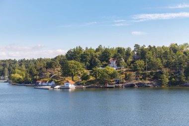 Stockholm Takımadaları, yolcu gemisinden manzara. Kıyıdaki kulübeler