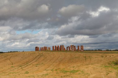 Büyük Britanya, Smiltene, Letonya 'daki ünlü Stonehenge' i andıran gayri resmi bir turizm merkezi olan çiçek tarlasının ortasında kayalardan ve kırmızı tuğlalardan yapılmış eski bir ahırın kalıntıları.