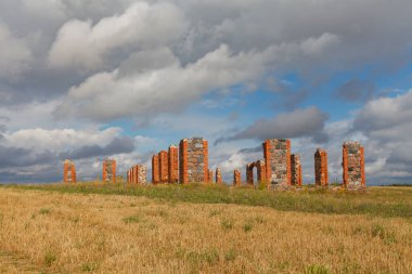 ruins of an old barn made of boulders and red bricks in the middle of a field of cornflowers, an unofficial tourist attraction that resembles the famous Stonehenge in Great Britain, Smiltene, Latvia clipart