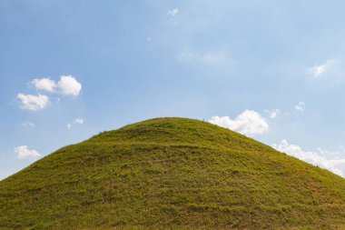 Ideal green round hill and blue sky with clouds above it. Krakus Mound, Krakow, Poland. clipart