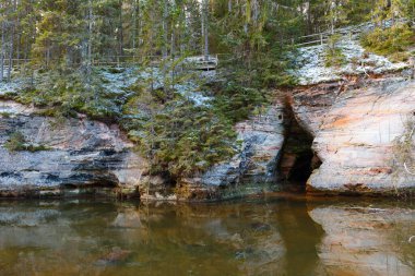 Nehir boyunca kumtaşı kayalıkları açığa çıktı. Kış mevsimi. Estonya.