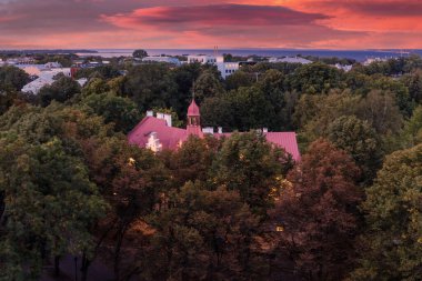 Yeşil parkla çevrili eski bir bina. Gece manzarası Tallinn, Estonya. Dramatik gün batımı gökyüzü