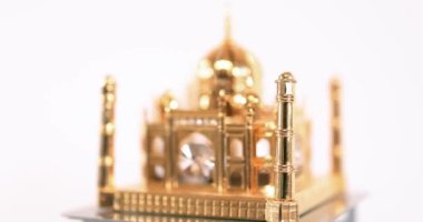 Close up view of golden Taj Mahal model  on a rotating display.