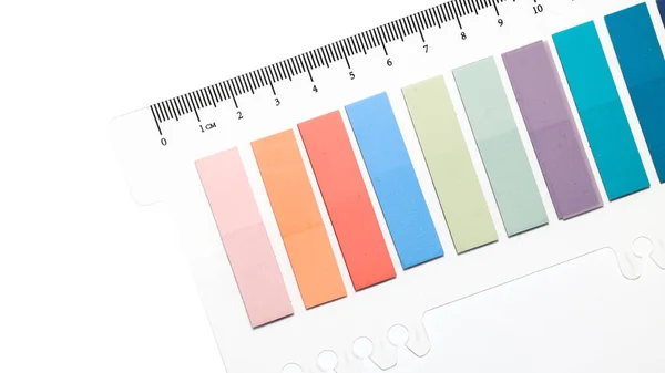 Beyaz Arkaplanda Şeffaf Plastik Sayfa Üzerindeki Renkli Yapışkan Sekmeler — Stok fotoğraf