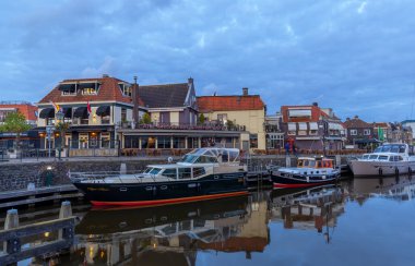 LEMMER, NETHERLANDS - 16 Mayıs 2023: Hollanda 'nın en önemli balıkçılık kasabalarından biri olan Friesland' ın tarihi liman kenti Lemmer Centrum 'un kanallarında renkli tekneler.