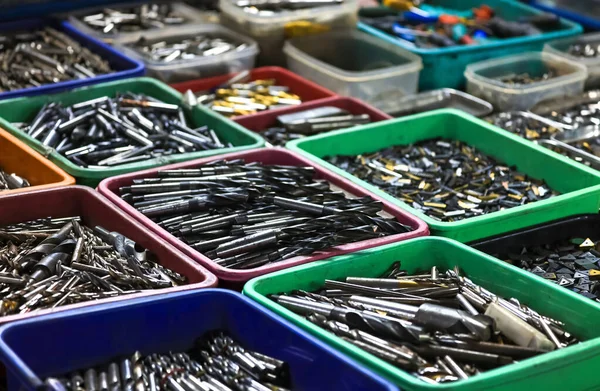 stock image Colorful bins with assorted used machine tool cutting tools up for sale in the market, selective focus.