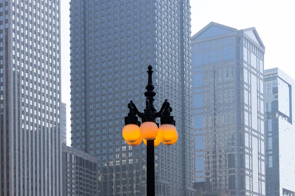 Lámpara Alta Con Luces Bola Encendidas Contra Altos Edificios Modernos —  Fotos de Stock