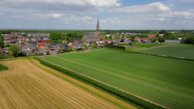 Hollanda 'nın Warvershoof belediyesindeki tarihi kilise ve renkli Hollanda tarzı evlerin havadan görünüşü.