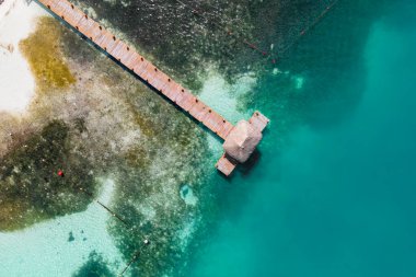 Cancun sahilindeki ahşap bir iskelede küçük bir kulübeye tepeden bakınca Cancun, Latin Amerika 'nın önde gelen turizm merkezlerinden biridir..