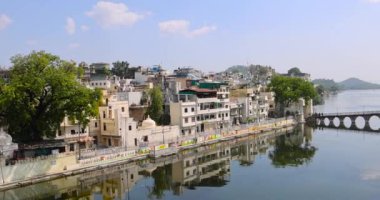 Udaipur, Rajasthan, Hindistan - 13 Ekim 2022: Hindistan 'ın Udaipur kenti, Rajasthan' daki Pichola Gölü boyunca yer alan 400 yıllık tarihi şehir sarayı ve diğer tarihi binaların dış görünüşü