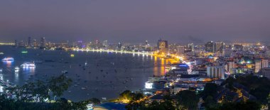 Pattaya, Tayland - 18 Aralık 2023: Tayland 'ın en büyük sekizinci şehri olan alacakaranlıkta Pattaya şehir ve denizinin panoramik manzarası.