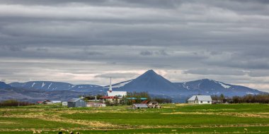 Church at small village Brogans, Iceland under cloudy sky. clipart