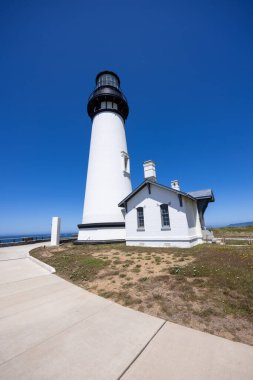 Yaquina Head Lighthouse against blue sky, along Pacific coast in Oregon state, USA. clipart