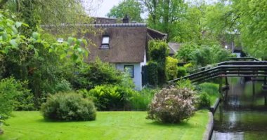 Hollanda 'nın ünlü Giethoorn köyündeki kanalların oradaki çatı evler..