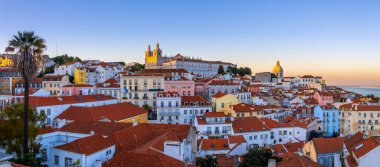 Lizbon, Portekiz 'in ufuk çizgisinin panoramik manzarası, alacakaranlık sırasında Alfama bölgesinde birçok renkli ev.