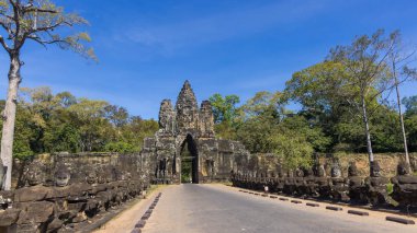 Tonle Om Güney Kapısı Köprüsü, Bayon Tapınağı kompleksi, Kamboçya, mavi gökyüzüne karşı.