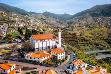 Dağ yamacında yüksek kilisesi olan Madeira adasının kırsal manzarası..