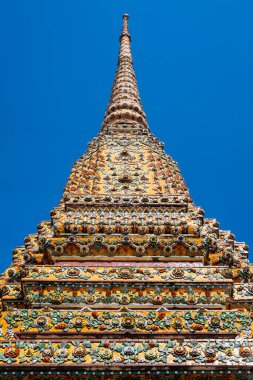 Tarihi Wat Pho tapınağının karmaşık mimarisi Bangkok, Tayland 'da mavi gökyüzüne karşı.