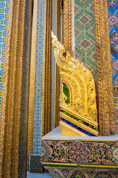 stock image Colorful intricate decor on gold painted Thai temple pillars close up view.