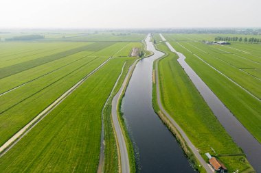 Hollanda 'nın kırsal kesimlerinde kanalları olan engin açık tarım arazilerinin havadan görünüşü.