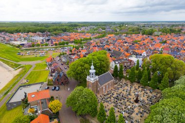 URK, Hollanda - 16 Mayıs 2023: Hollanda 'nın Urk kentindeki tarihi kilise ve renkli Hollanda tarzı evlerin havadan görünüşü.