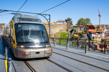Porto, Portekiz - 22 Nisan 2024: Don Luis Köprüsü raylarındaki Porto elektrikli metro tramvayının önden yakın görüntüsü.