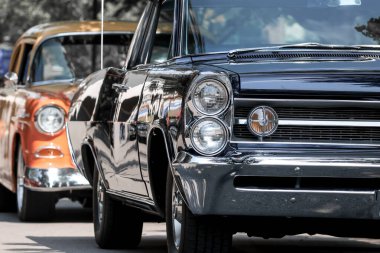 Ön baş lambadan klasik siyah kaslı araba görüntüsü.