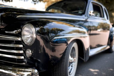 The Classical black muscle car front head lamps view. At vintage car show. clipart