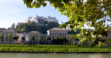 Hohensalzburg Kalesi 'nin panoramik manzarası, bir tepenin üstündeki büyük bir ortaçağ kalesi Salzburg şehrine bakıyor..