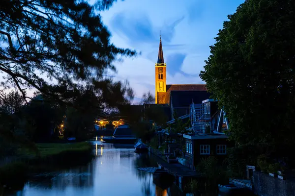 stock image Scenic landscape of schermerhorn city with illuminated church during blue hour in The Netherlands.