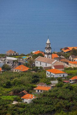 Portekiz 'in Madeira Adası' ndaki Idyllic Hillside Village with Scenic Church and Red-Roofed Homes.