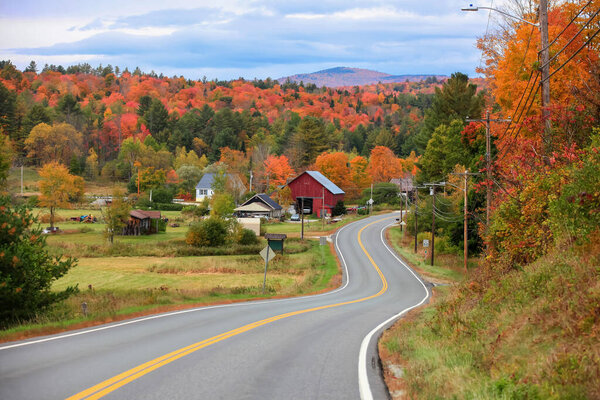 Old Barn by the highway in rural Vermont with colorful fall foliage