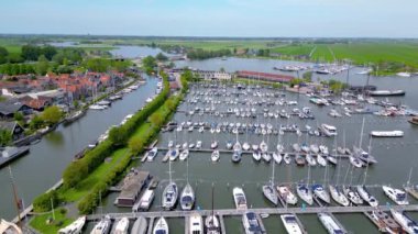 Volendam, Hollanda - 16 Mayıs 2023: Volendam, Hollanda 'da renkli binalar ve liman manzarası.