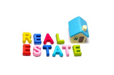 Oyuncak mektuplar ve beyaz arka planda oyuncak evlerle yapılmış gayrimenkul ve konut kavramı.