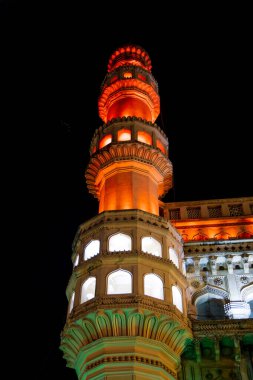 Tall minar of Charminar monument illuminated in the night time, in Hyderabad city, India