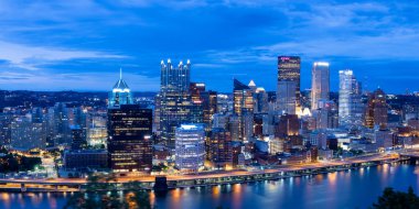 Pittsburgh, Birleşik Devletler - 09 Ağustos 2024: alacakaranlıkta Pittsburgh şehrinin silueti. Allegheny, Monongahela ve Ohio nehirlerinin birleştiği yerde..