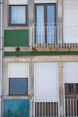 Renkli pencereleri ve kapıları olan eski iki katın dış görünüşünü kapat..