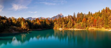 Panoramic view of autumn landscape at Urisee in Austria with turquoise water. clipart