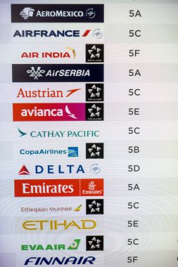 Chicago O'Hare International Airport, USA - September 08, 2024 : Digital boards showing International flight ticketing locations at Terminal 5. clipart