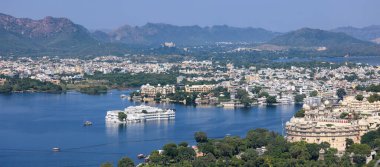 Udaipur, Rajasthan, Hindistan - 17 Ekim 2022: Gökyüzü manzaralı şehir sarayı ve Udaipur 'daki Pichola Gölü, güzel gölleri, sarayları ve tarihi eserleriyle tanınır..
