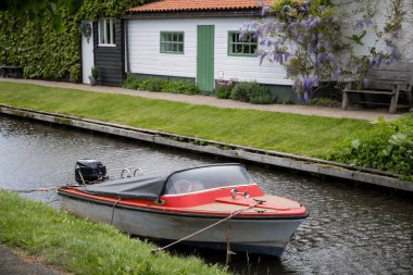 Hollanda 'nın Giethoorn köyündeki kanalda küçük kırmızı bir tekne..