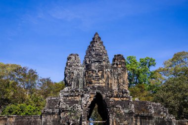 Tonle Om Güney Kapısı Köprüsü, Kamboçya 'daki Bayon Tapınağı kompleksinde mavi gökyüzüne karşı.