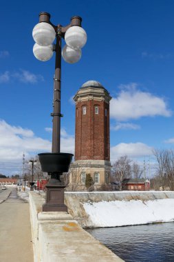 Tall historic Manistique water tower in Michigan upper peninsula winter time. clipart