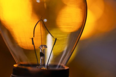 Işıklandırma arka planına sahip yanan ampulün aşırı yakın görüntüsü.