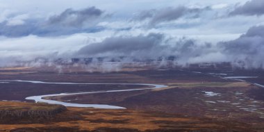 Panoramic view of cloud cover mountains in the middle of Tundra landscape in scenic Iceland countryside. clipart