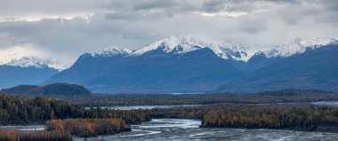 Manzaralı panoramik kar, sonbahar sonunda Alaska 'da alçak seviyeli bulutlarla kaplı dağ manzarası..
