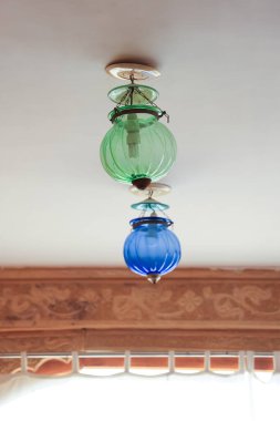 Beyaz tavanda iki renkli geleneksel tavan lambası.