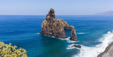 Madeira Adası Praia da Ribeira da Janela 'daki yüksek volkanik kaya oluşumlarının panoramik görüntüsü.